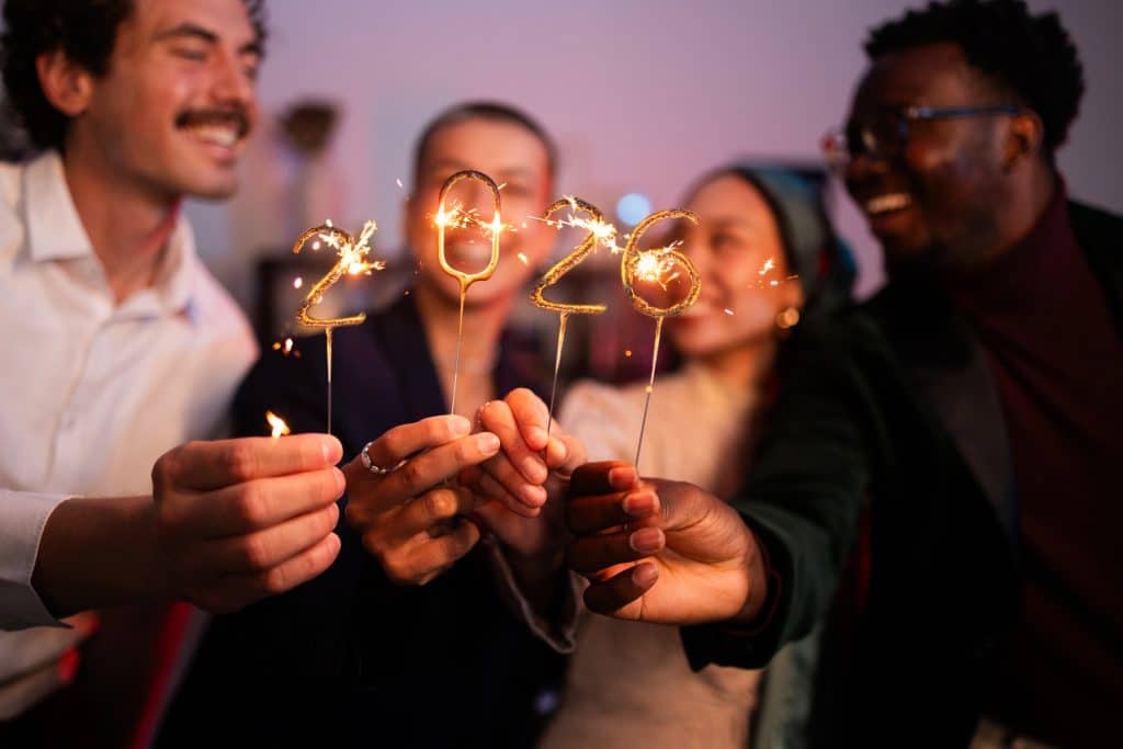 Group of friends celebrating the new year 2026 together with sparklers