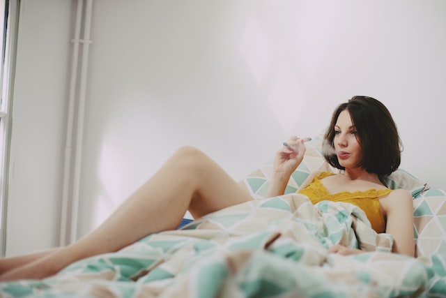 woman in bed smoking marijuana